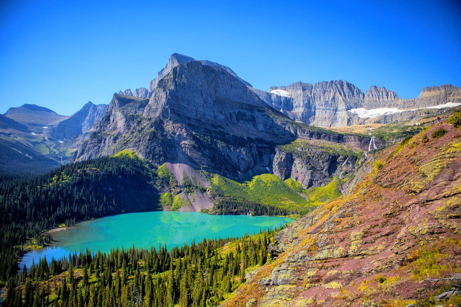 Le lac Grinnell aux eaux turquoises et les pics montagneux environnants vus depuis le sentier du glacier Grinnell dans le parc national de Glacier.