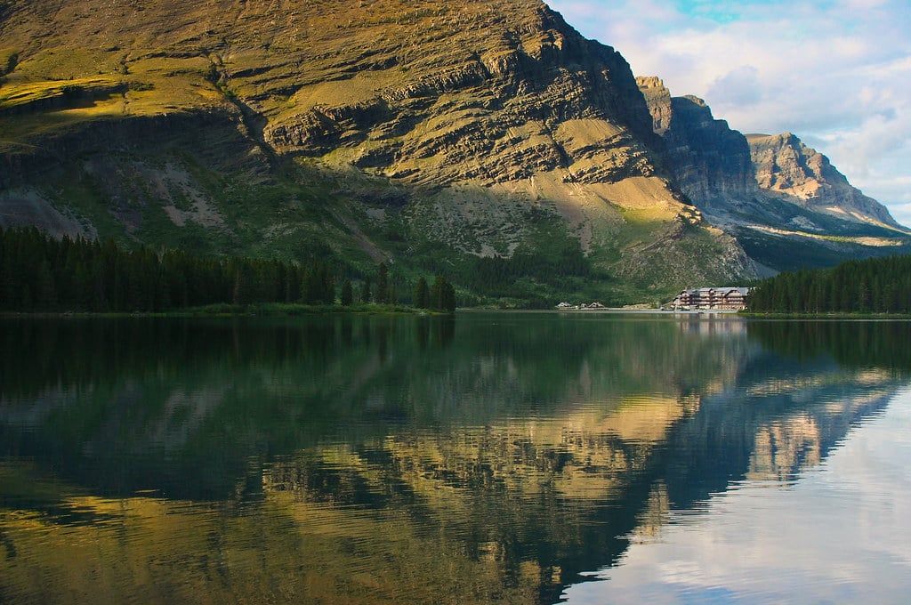 Many Glacier Hotel sits along the shore of Swiftcurrent Lake beneath rugged peaks in Glacier National Park.